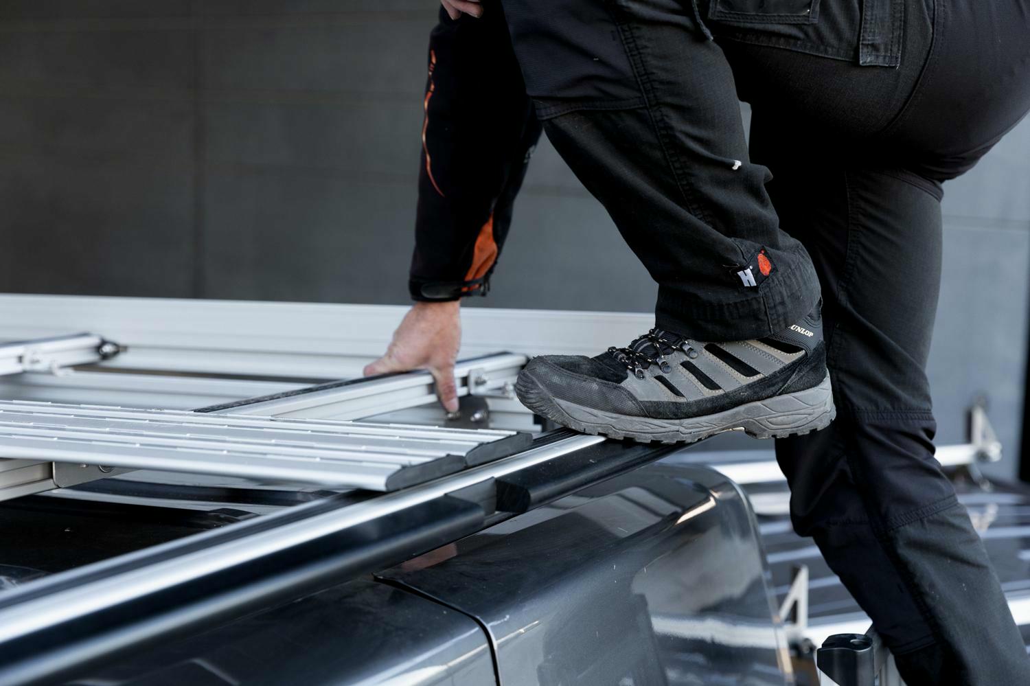Handwerker steigt über das patentierte mSlide-System auf einen mobietec Dachträger